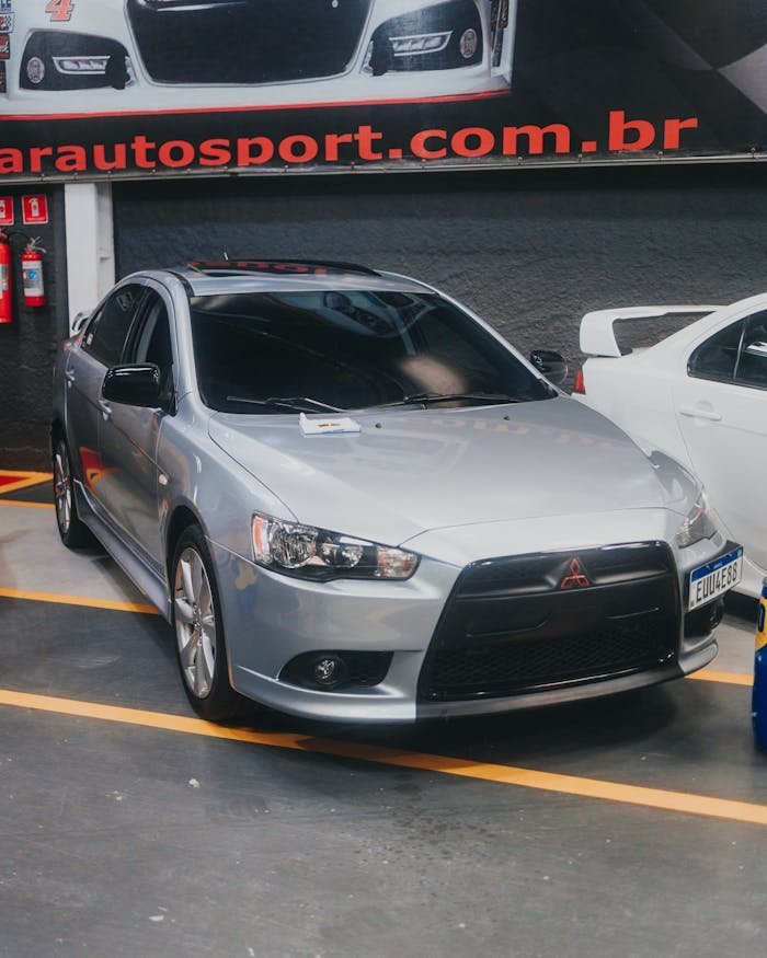 Stylish silver Mitsubishi Lancer displayed in a modern car dealership showroom, Brazil.